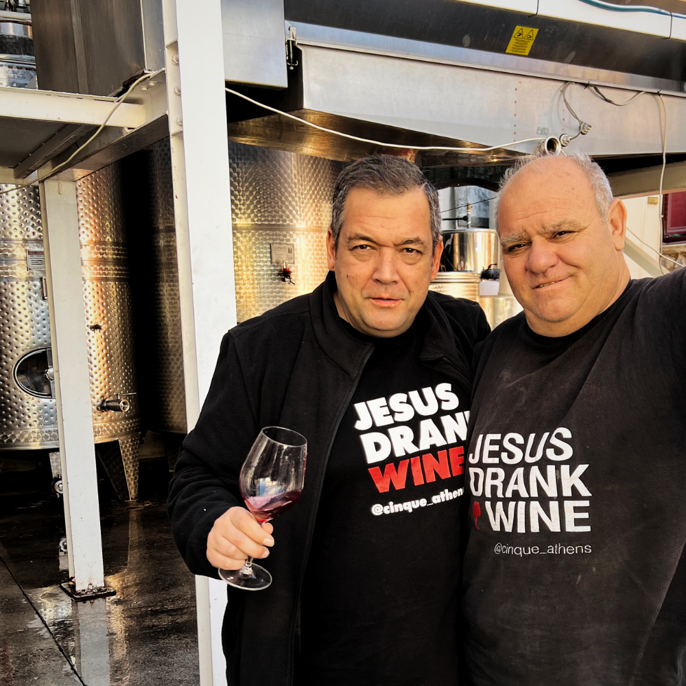 Grigoris Prassas and Panagiotis Katrisiosis posing for the camera after trying a glass of freshly produced wine at the Thivaiki Gi vineyard.